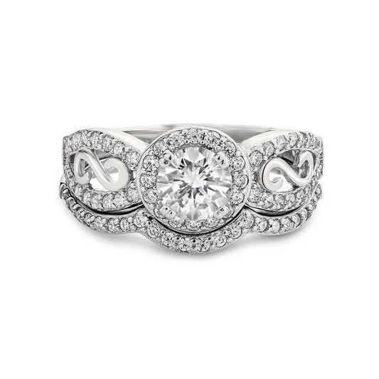 The Miele sterling silver bridal set showcases a beautifully crafted ring with intricate scrollwork, featuring a round central diamond complemented by smaller diamonds on the band, making it an ideal choice for a bridal set.