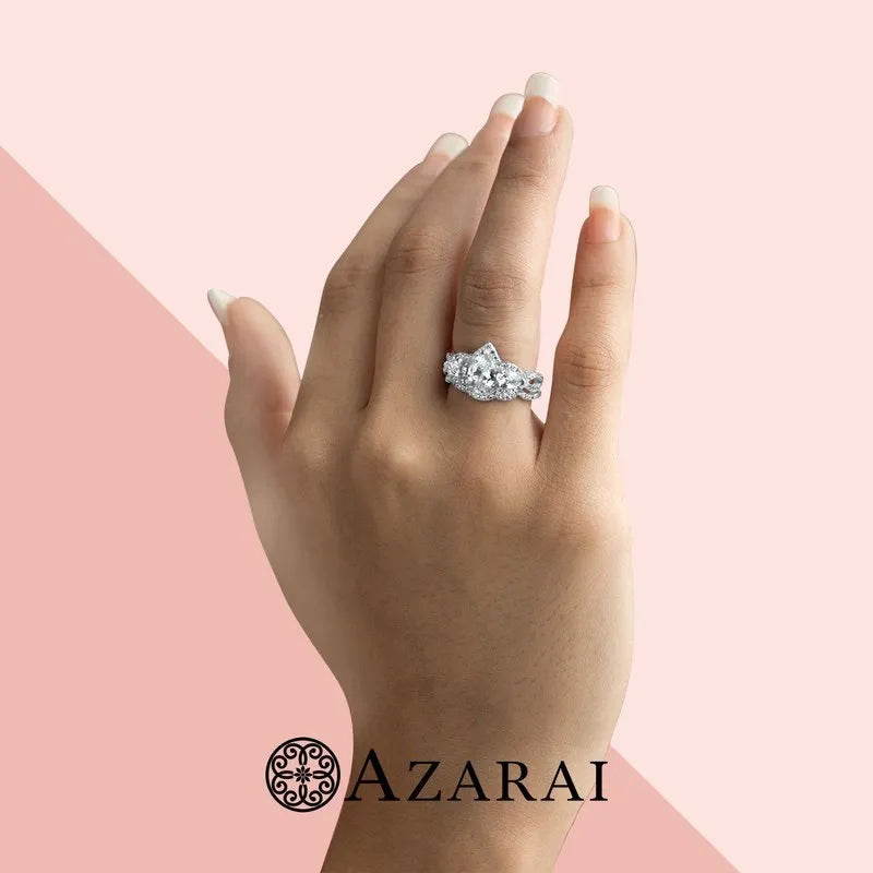 A hand adorned with the Alyssa sterling silver bridal set, featuring a large diamond ring against a pink background, with the "Azarai" logo at the bottom.