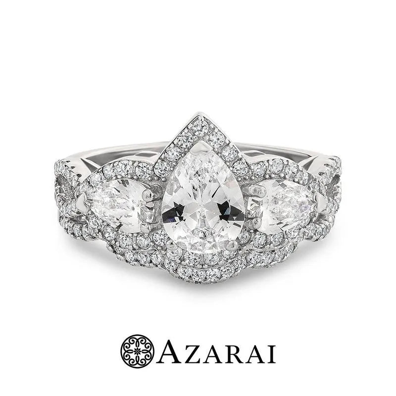 The Alyssa sterling silver bridal set features a stunning pear-shaped diamond ring that sits elegantly in sterling silver. This exquisite piece is flanked by two smaller side diamonds and encircled by a halo of radiant stones, making it a perfect complement to the beauty of its wearer.