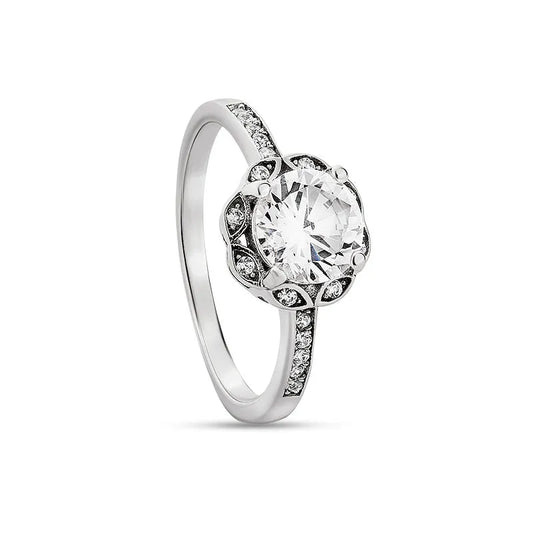 The Anais sterling silver engagement ring showcases a prominent, round central diamond, elegantly accented by smaller diamonds encircling it and adorning the band.