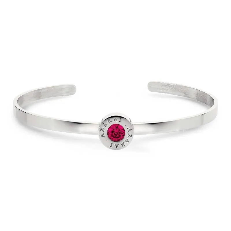 The Varia birthstone women's bracelet features a sophisticated silver cuff adorned with a centrally set round pink gemstone. The distinctive engraving of "AZARAI" encircles the birthstone, giving this stunning piece its unique charm.