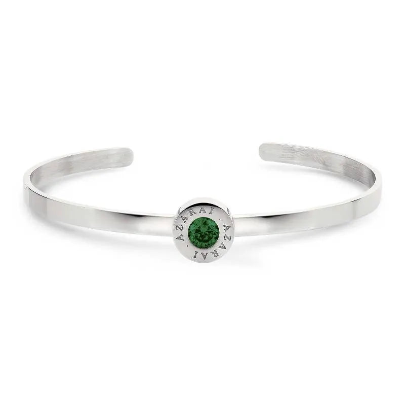 Introducing the Varia birthstone women's bracelet: a silver cuff adorned with a round green gemstone at its center, beautifully encircled by the engraved word “AZARAI.”