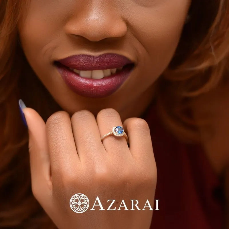 A woman smiling while showcasing an Adeline engagement ring, featuring a stunning 9kt gold design. "AZARAI" is written at the bottom.