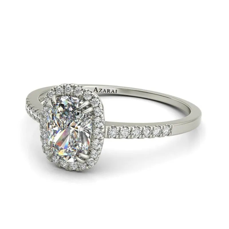 The Adeline 9kt gold engagement ring showcases an oval diamond with a halo setting and a band accented with diamonds.