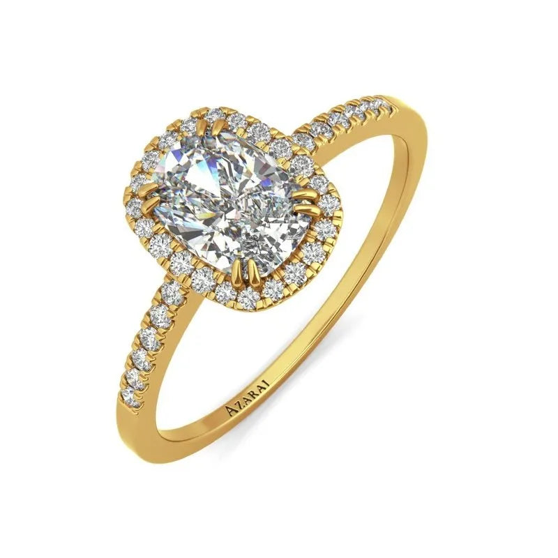 The Adeline 9kt gold engagement ring showcases a cushion-cut diamond center, encircled by smaller diamonds, with additional diamonds adorning the band.