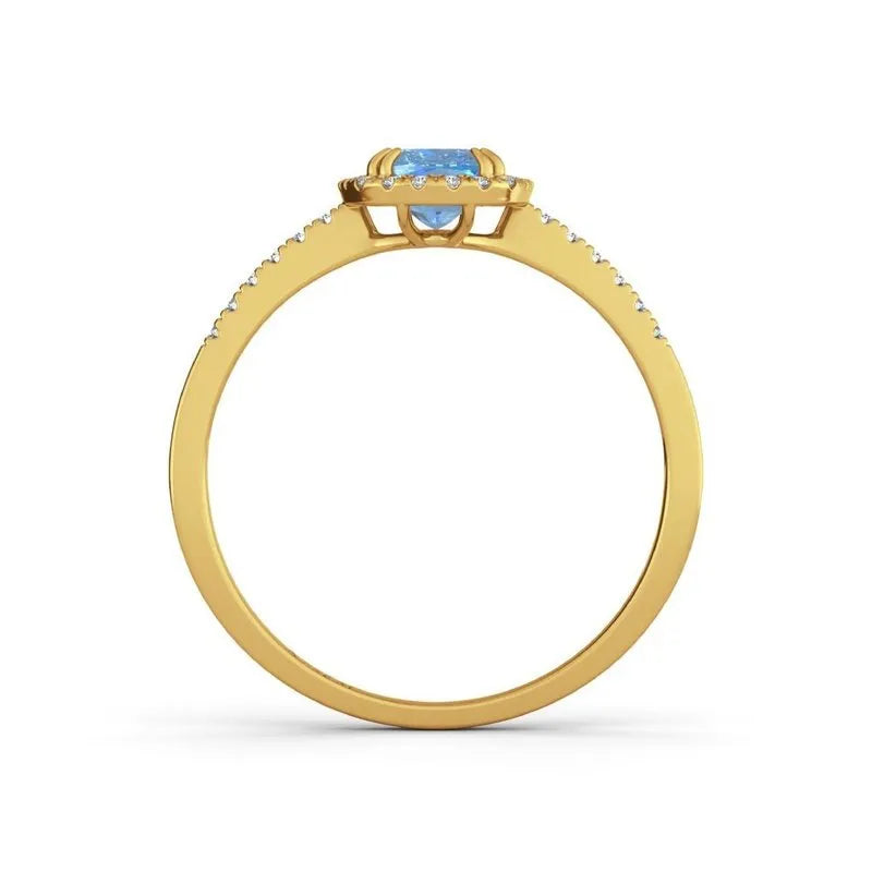 The Adeline 9kt gold engagement ring showcases a captivating blue gemstone at its centerpiece, complemented by delicate clear stones elegantly adorning the band.