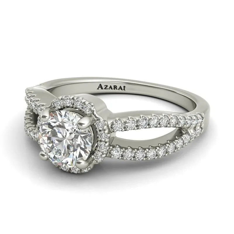 Angelika introduces a breathtaking sterling silver engagement ring on clearance, adorned with a prominent round diamond at its center and accented by smaller diamonds along the band.