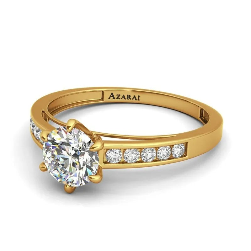 The Anna 9kt gold engagement ring showcases a large round diamond centerpiece, accompanied by smaller diamonds set along the intricately engraved band that reads "Azarai.