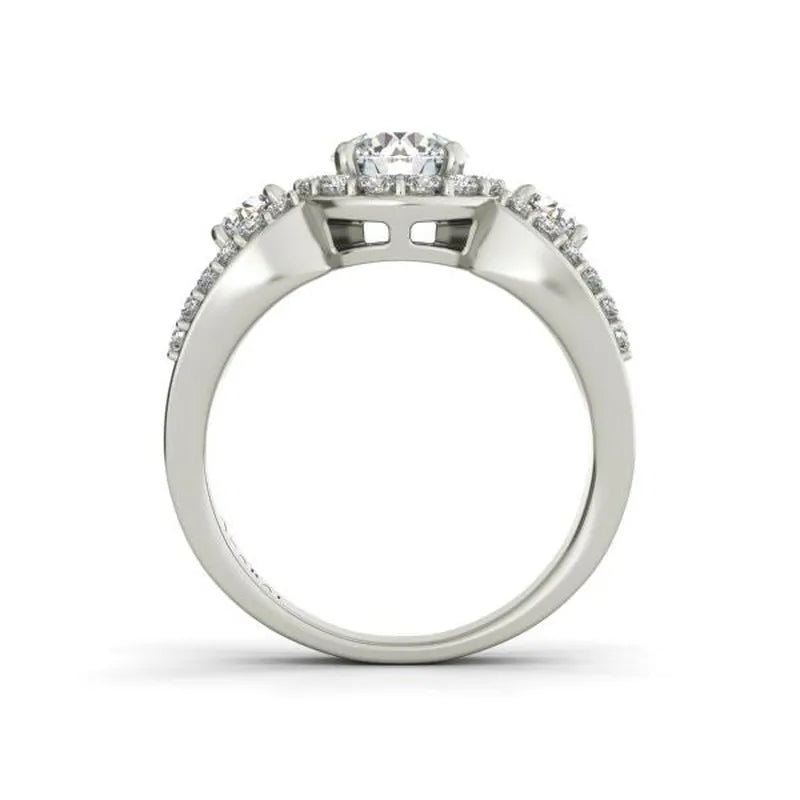 The Aurora sterling silver engagement ring features a magnificent round center diamond complemented by smaller diamonds elegantly set along the band.