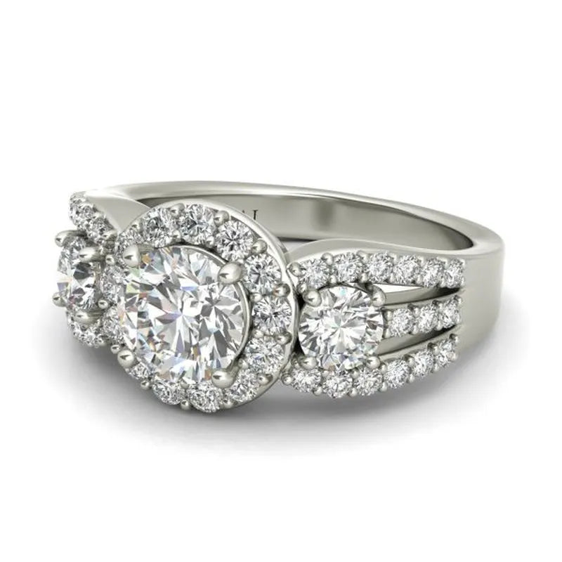 The Aurora sterling silver engagement ring showcases three round-cut diamonds surrounded by smaller stones on a split shank band.