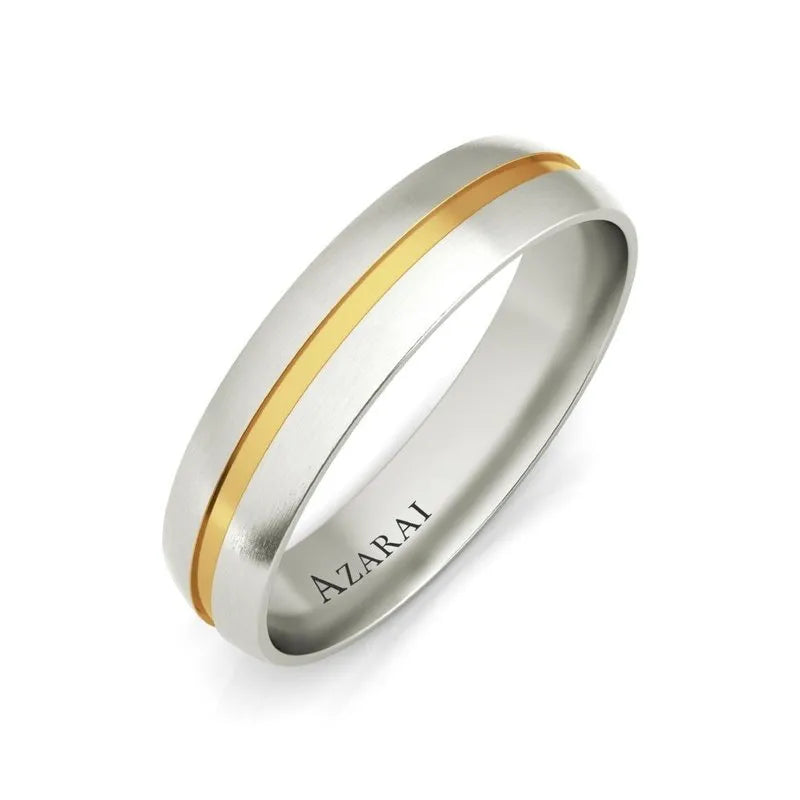 The Burke 18kt gold wedding band boasts a sleek silver ring with a smooth finish, accentuated by an elegantly engraved central band.