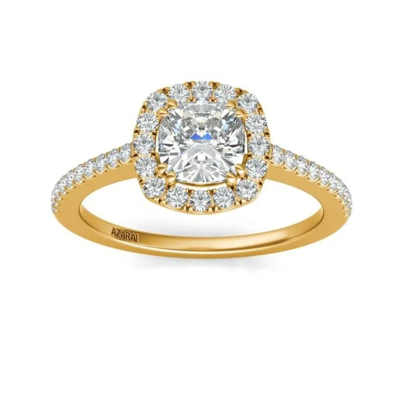 The Celeste 14kt gold engagement ring features a cushion-cut diamond at its center, surrounded by smaller diamonds and additional sparkle adorning the band.