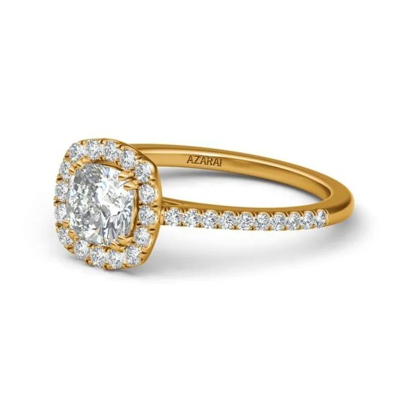 The Celeste 14kt gold engagement ring showcases a cushion-cut diamond surrounded by a halo of smaller diamonds, all set in a radiant 14kt gold band.