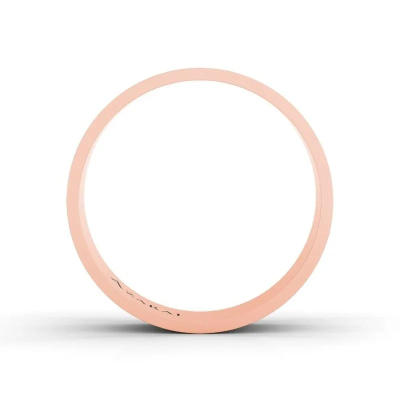 A slim, rose gold ring featuring a minimalist band design stands out against a white background, evoking the elegance of the Chandler 18kt gold wedding band.