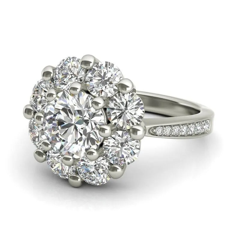 Introducing the Charlotte sterling silver engagement ring, now available at an attractive clearance price. This exquisite piece features a cluster of round, sparkling diamonds in a floral design, beautifully complemented by additional small diamonds on the band. Perfect as an elegant engagement ring or a dazzling addition to your collection.