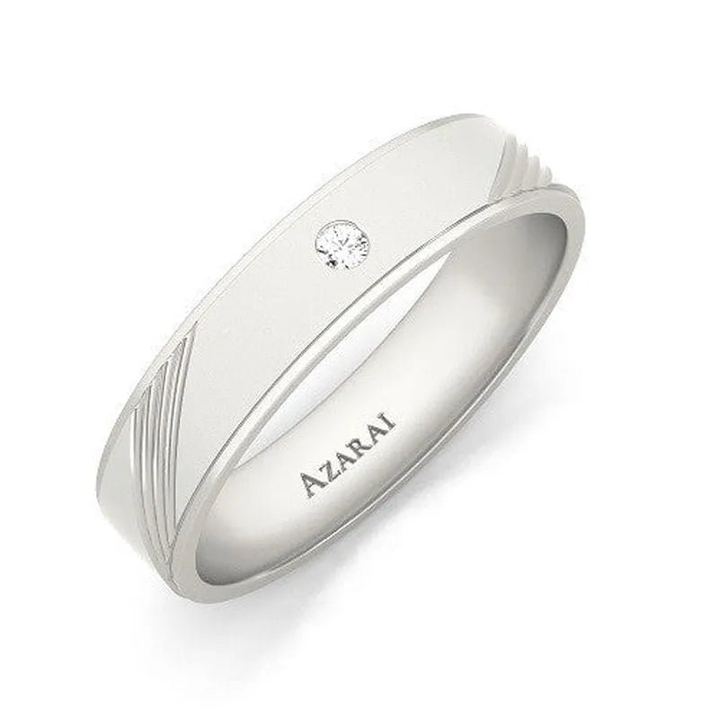 The Tristan sterling silver wedding band by AZARAI, featuring a single small diamond and engraved lines, is available on clearance.