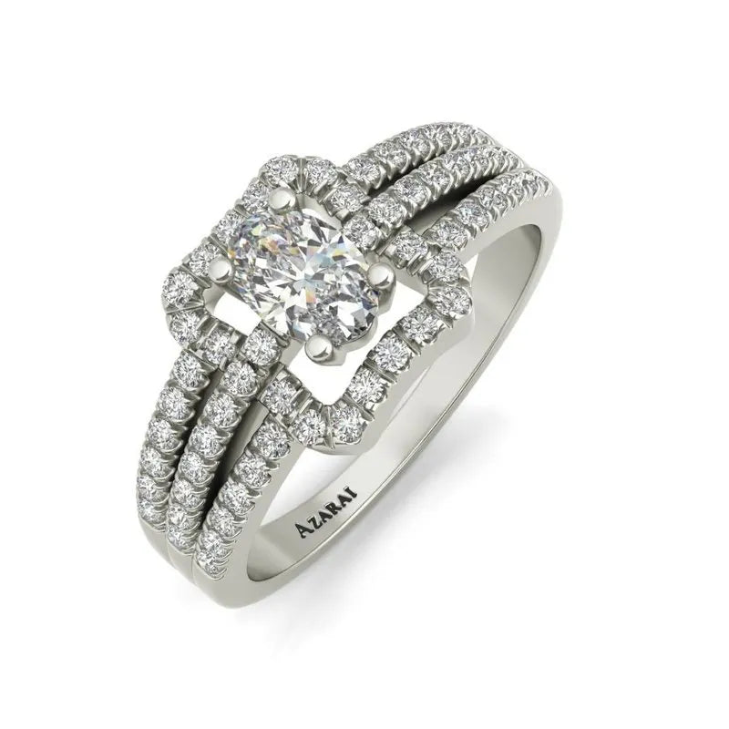 The Esmee sterling silver engagement ring, now on clearance, is a stunning piece featuring a prominent oval diamond at its center, surrounded by a striking rectangular arrangement of smaller diamonds that extend onto the band.