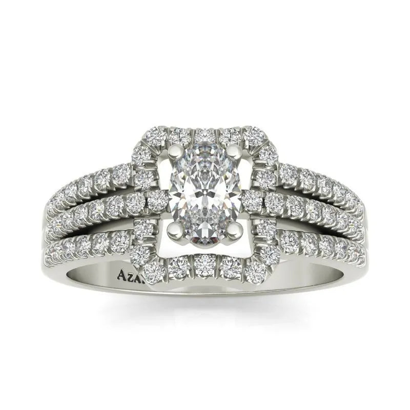 The Esmee sterling silver engagement ring, now available on clearance, features a central oval diamond surrounded by smaller diamonds. Its triple diamond-encrusted band adds a touch of elegance to this stunning piece.