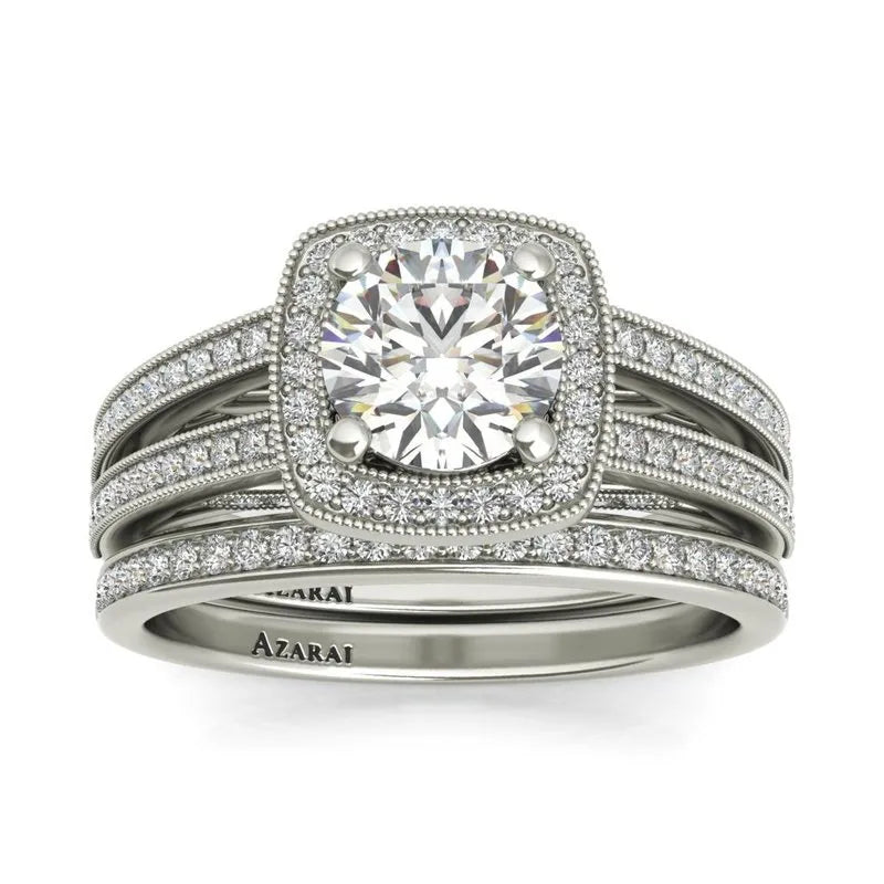 This Eva sterling silver bridal set ON CLEARANCE showcases a captivating engagement ring highlighted by a large round diamond and enhanced with numerous smaller diamonds along the band, elegantly paired with two matching diamond-studded bands.