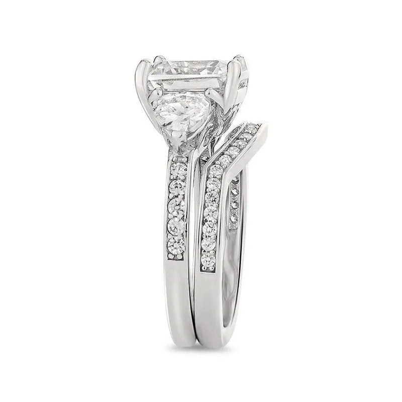 Introducing the Guinevere sterling silver bridal set: an engagement ring featuring a stunning square-cut diamond, flanked by a band of smaller diamonds that gracefully encompass the prongs and shank.