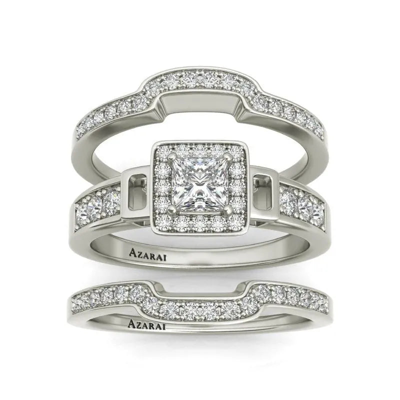 The Henriette sterling silver bridal set, now on clearance, includes three stunning rings embellished with embedded diamonds. The centerpiece square, elegantly encircled by smaller diamonds, takes center stage, flanked by two matching bands below.