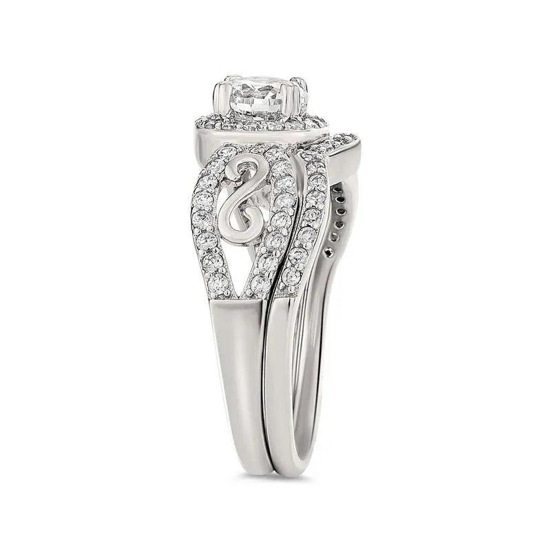 The Miele sterling silver bridal set includes a striking engagement ring with an intricate swirl design and embedded small diamonds, featuring a single round-cut diamond at the center. This stunning piece elegantly captures timeless beauty for your special day.