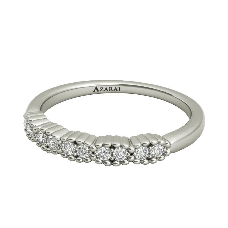 The Nina sterling silver wedding band showcases a row of small round diamonds elegantly positioned along one side, with "AZARAI" gracefully engraved on the inner band. This exquisite piece exemplifies timeless beauty and sophistication, perfectly capturing Nina's impeccable taste for a wedding band.