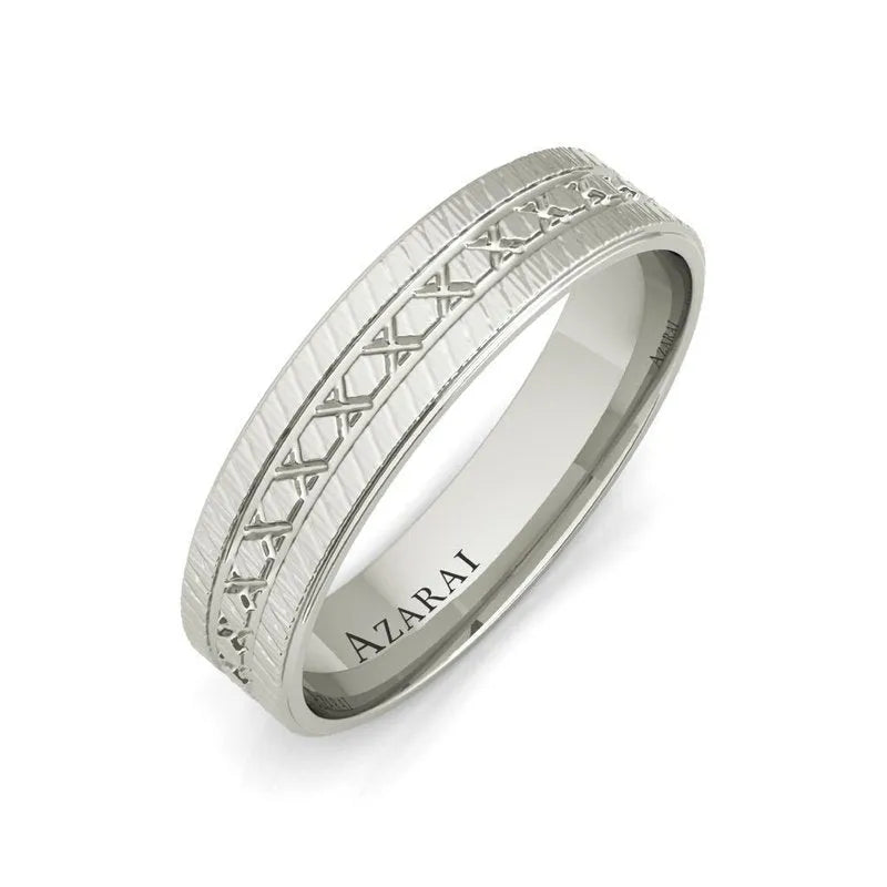 The Parker sterling silver wedding band features a textured pattern and an engraved design along the center, making it an ideal choice for a men's wedding band. The interior is marked with the name "AZARAI," adding a personal touch to this elegant piece.