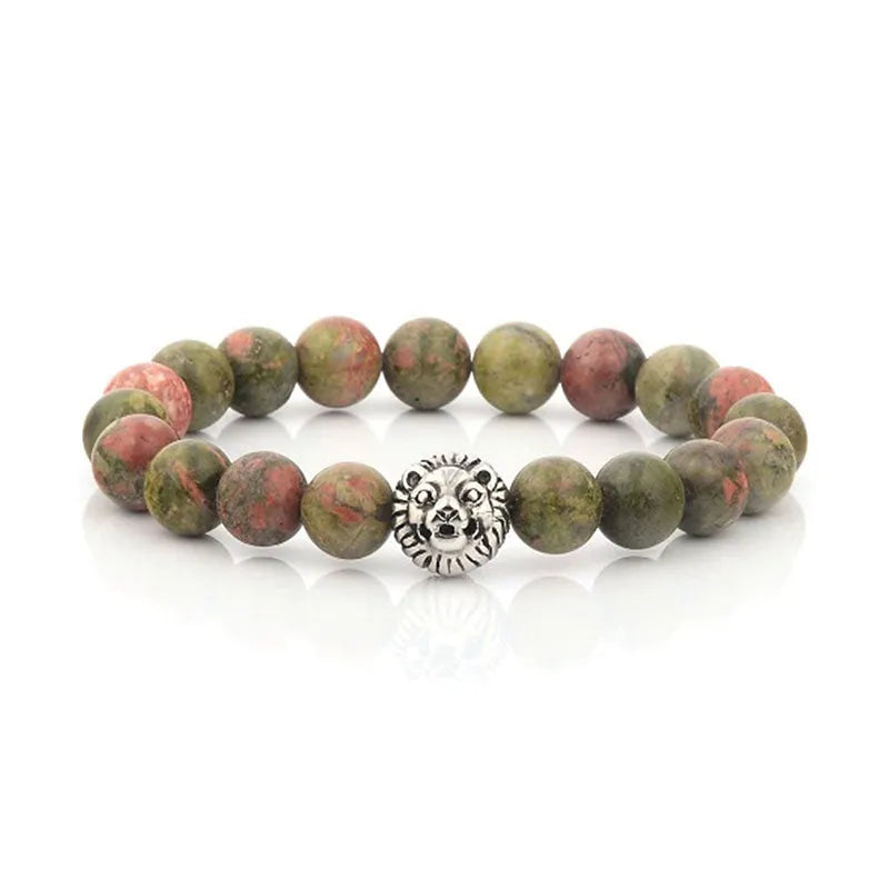 The Roka beaded bracelet for men features vibrant green and pink semi-precious stones, highlighted by a striking silver lion head charm, all elegantly packaged in a gift box.