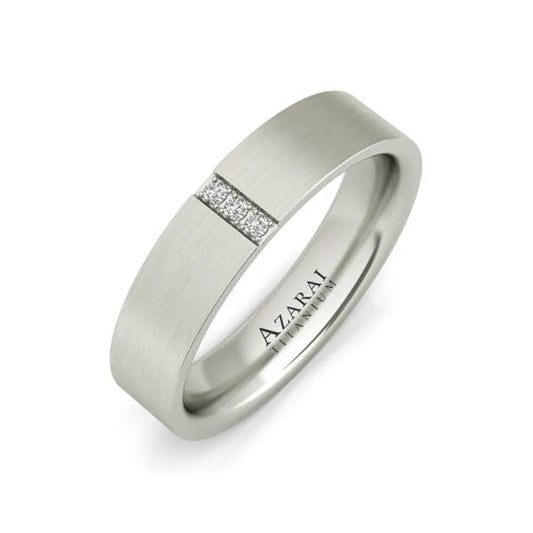 The Rowan titanium wedding band, now on clearance, features a matte-finish silver ring with a row of small embedded diamonds and the interior is engraved with "AZARAI TITANIUM," exuding timeless elegance.