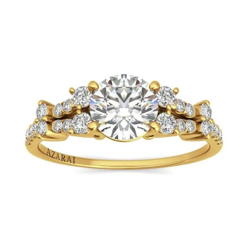 The Sweetheart 14kt gold engagement ring features a large central diamond encircled by smaller diamonds on the band and is elegantly engraved with "AZARAI," embodying timeless beauty.